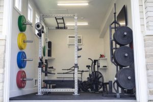 En komplett skivstångsställning och träningsutrustning i ett välorganiserat hemmagym.