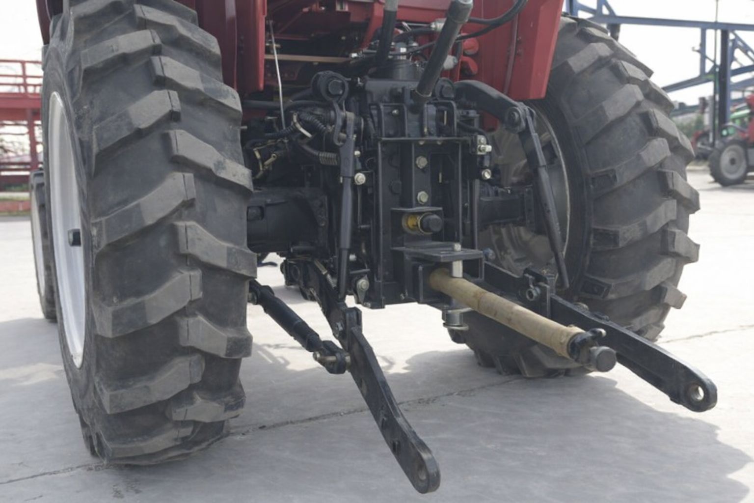 Närbild på bakre kraftuttag och trepunktslyft på en röd traktor inför auktion.